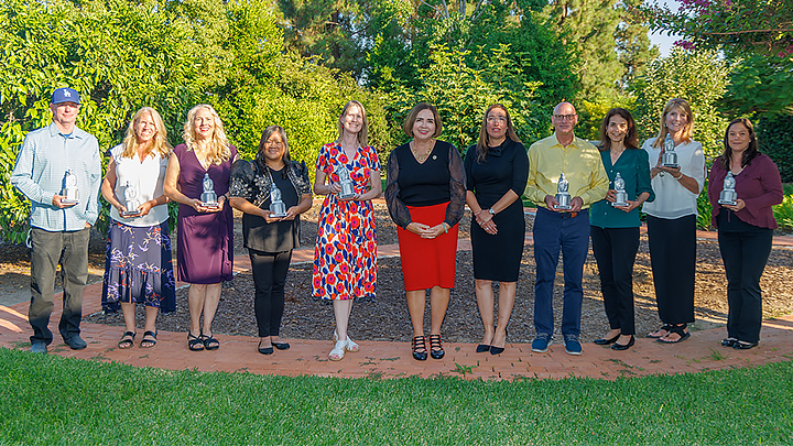 group of people outside holding awards