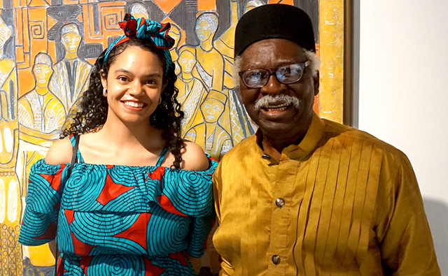 Africana Studies student Akilah Wayne stands next to Bruce Onobrakpeya at the art gallery where his works were displayed. 