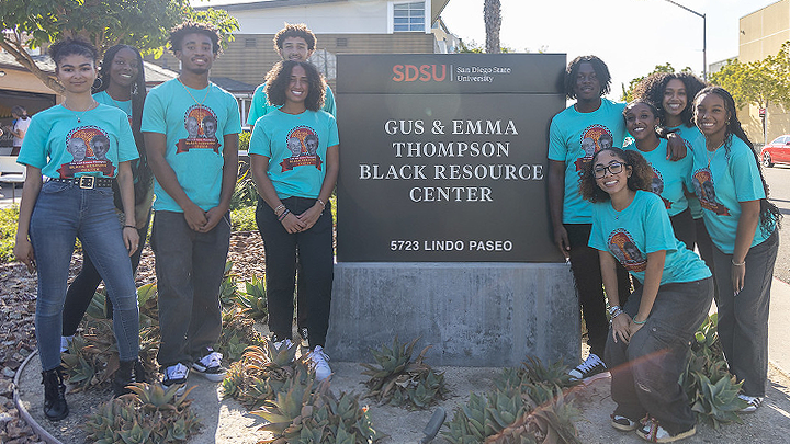 students stand near sign for Gus & Emma Thompson Black Resource Center (BRC)