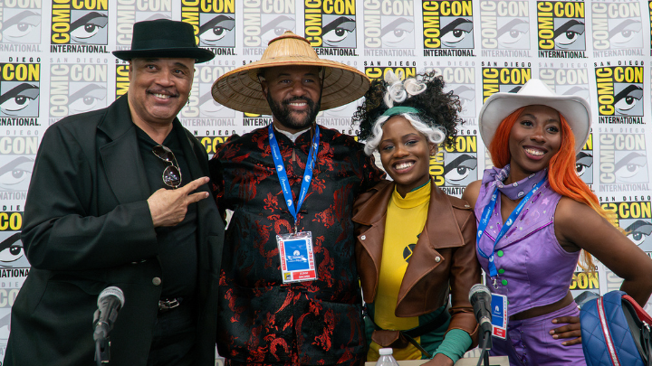 two mean and two women at Comic Con, three are dressed in cosplay costumes
