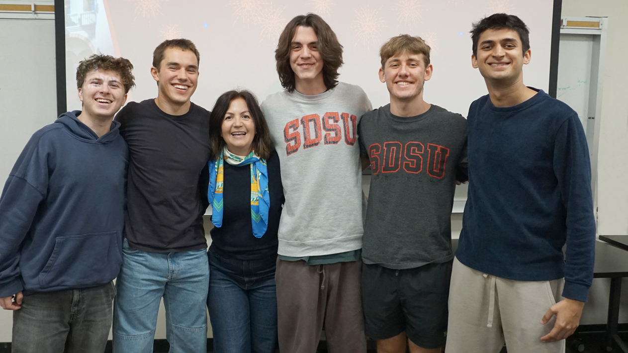 5 students and 1 professor pose smiling