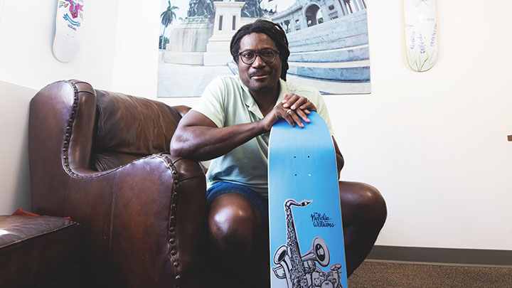 man sits in chair with skateboard